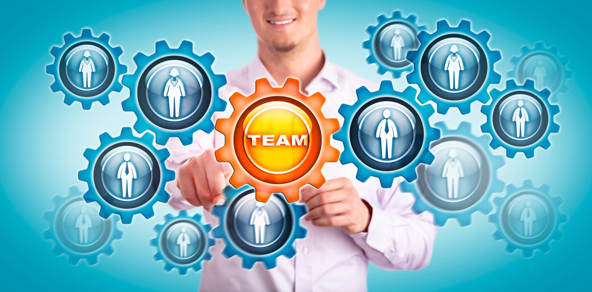 Young Smiling Man Touching TEAM In Gear Train Young smiling man in shirt touching a virtual cogwheel labeled TEAM in a gear train of employees. Human resources concept for team building, teamwork, talent development, recruitment, HRM, strategy.